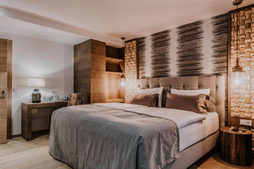 Familienzimmer mit Doppelbett, Nachttisch mit Lampe, Schreibtisch und Sessel