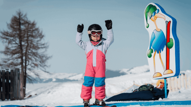 Kind jubelt beim Ski fahren