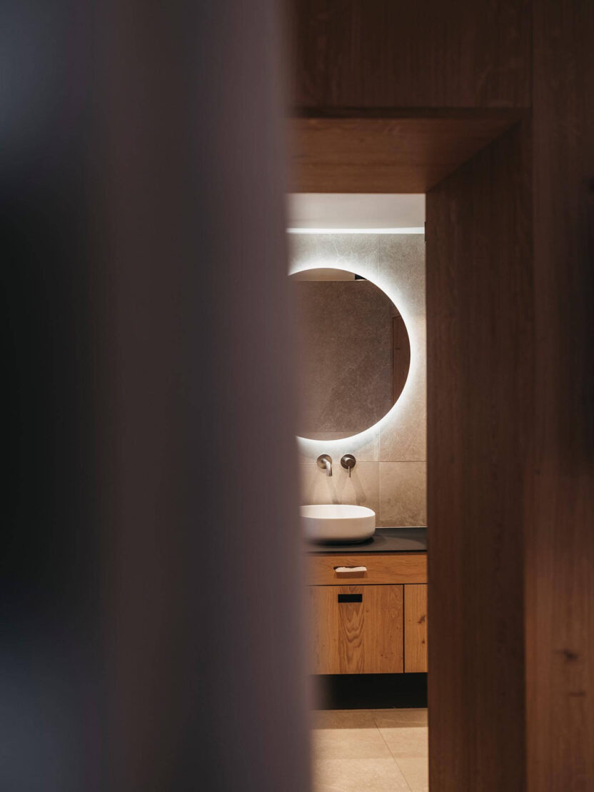 Badezimmer mit Waschbecken, beleuchteten Spiegel und Stauraum